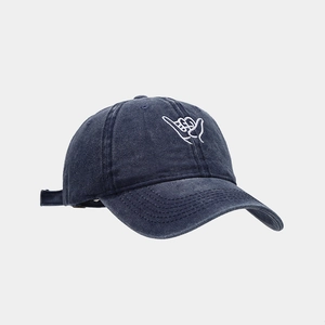 Close-up of navy washed canvas baseball cap with white hand gesture embroidery detail