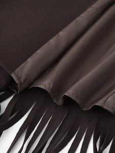 Close-up macro detail of dark brown wool fabric texture and fringe tassels on a coat