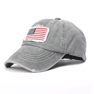 Detail of grey washed cotton baseball cap with American flag patch and distressed holes