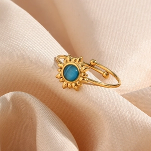 Adjustable gold sunburst ring featuring a round blue cat-eye stone on pink satin