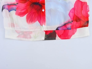 Detailed macro view of floral chiffon fabric with white buttons and delicate print texture