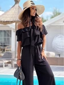 Detail of off-the-shoulder black summer jumpsuit with ruffle neckline and drawstring waist
