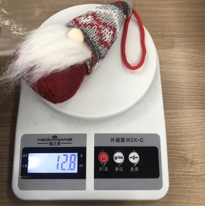 Christmas gnome plush hanging ornament shown weighing 12.8g on a digital scale
