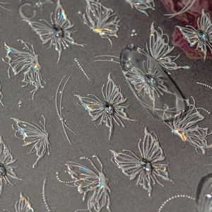 Detailed macro view of 5D white butterfly nail sticker with laser glitter and diamond accent