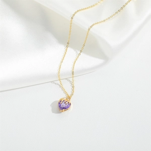 Detail of a purple heart zircon pendant on a gold necklace over soft white silk fabric