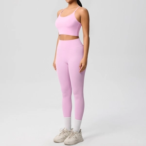 Pink yoga set featuring cross-back sports bra and high-waisted leggings on model
