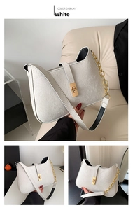 Detail view of white leather shoulder bag with gold chain strap and textured finish