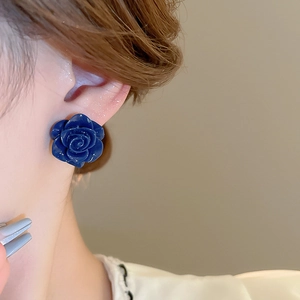 Gros plan d'un mannequin portant une boucle d'oreille rose bleu marine en résine texturée