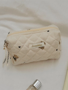 Quilted corduroy bear cosmetic bag with embroidered hearts and branding ribbon