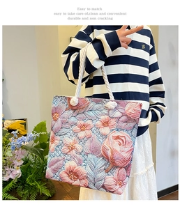 Detailed view of floral embroidery on a large canvas tote bag with thick rope handles