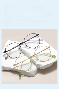 Detailed view of black and gold square metal glasses frames on white stone display
