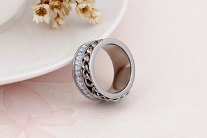 Detail of silver stainless steel wide ring with Cuban chain and shimmering inlay