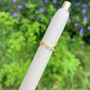 Detailed view of an 18K gold plated cross ring with twisted band and pave cubic zirconia