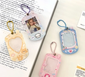 Detailed view of four colorful acrylic puppy photo frame keychains with beaded chains