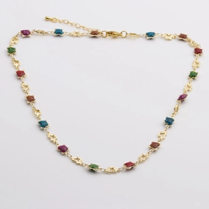 Détail d'un collier chaîne à maillons étoiles dorés avec émail coloré et fermoir mousqueton