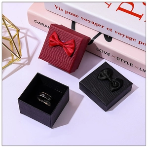 Detail shot of mini jewelry gift box with satin bow on a decorative background