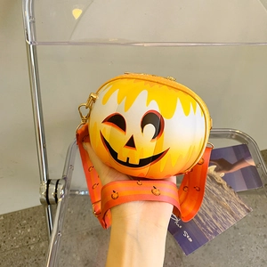 Detail of creative pumpkin-shaped crossbody bag with cartoon smiley face and wide strap