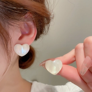 Detail view of heart-shaped mermaid pearl earrings worn to show elegant style and luster