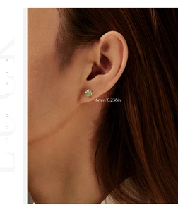 Close-up of 6mm round yellow champagne stud earring with four-claw setting on model