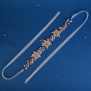 Elegant gold snowflake bridal headband with white ribbon and sparkling pearls for wedding hair