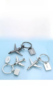 Detail view of polished metal airplane keychains in silver and gunmetal finish