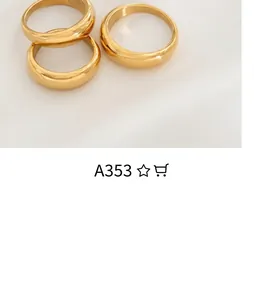 Close-up of three chunky gold-plated U-shaped rings on a vintage book page backdrop