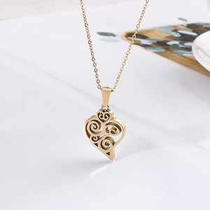 Detail shot of golden heart pendant necklace with intricate filigree vine pattern