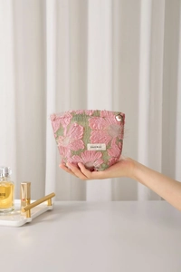 Close-up of pink 3D flower embroidery on cosmetic bag with petal-shaped metal zipper pull
