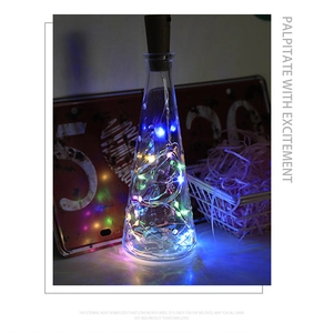 Detail of cone glass bottle with multicolor LED copper string lights and cork switch