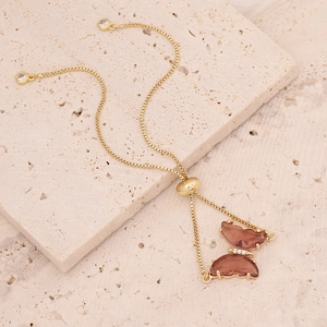 Detail of 18K gold butterfly bracelet with pink-brown stone and sparkling accents