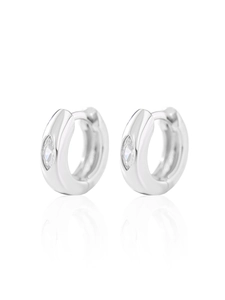 Macro shot of silver earrings with marquise-cut cubic zirconia on a mirror surface