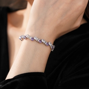 Macro detail of wave-shaped bracelet with purple amethysts and white zircon stones
