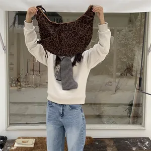 Large leopard print crescent shoulder bag in soft faux suede shown by a model