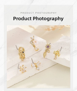 Set of 6 gold-plated L-shaped nose studs with zircon butterfly and moon designs on white marble