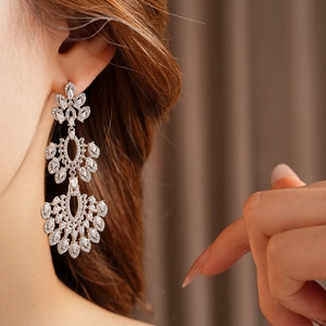 Détail de boucles d'oreilles vintage fleurs en argent avec zircons portées par un mannequin