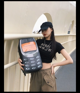 Detail view of retro mobile phone backpack with orange screen and creative lettering