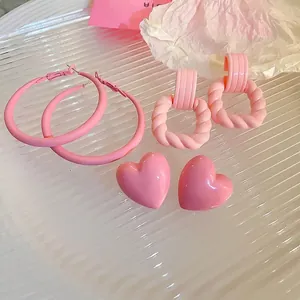 Set of three pink acrylic earrings featuring twist square dangles and heart shaped studs