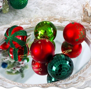 Detail der roten und grünen Weihnachtskugeln mit Glitzer auf einem weißen Tablett