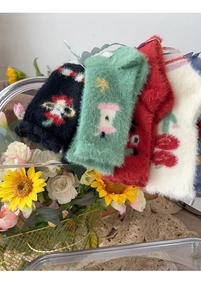 Detailed view of four pairs of plush winter socks with floral and holiday patterns