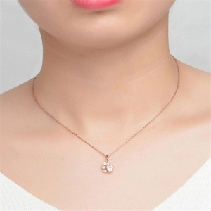 Detailed close-up of rose gold cat paw pendant with sparkling stones on a delicate chain