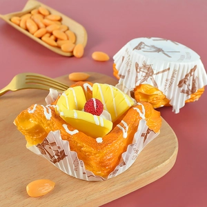 Close-up of artificial dessert with pineapple slice and berry in paper liner