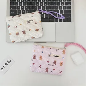 Close-up of floral quilted pouches with cartoon patterns and woven wrist straps