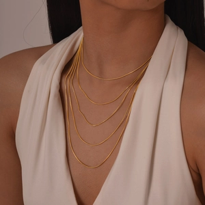 Vue détaillée du collier doré à 5 rangs de chaînes serpent portées par un mannequin