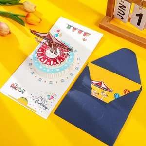 Detail of 3D pop-up birthday card featuring a colorful carousel with a blue envelope