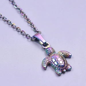Macro shot of minimalist stainless steel sea turtle pendant with vibrant rainbow finish