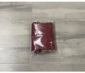 Detail view of a festive red Christmas stocking gift bag packed in protective transparent film