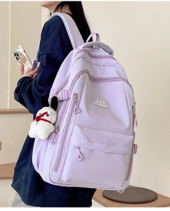 Detail of ergonomic purple nylon backpack with padded shoulder straps and cute bunny charm