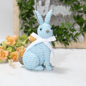 Close-up of light blue woven resin bunny with silk bow and intricate texture