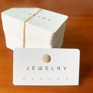 Macro view of white cardstock jewelry display cards with 6 holes and Jewelry text