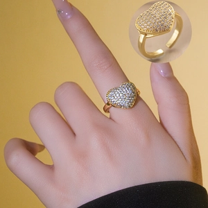 Close-up of a gold heart ring featuring pave zircon crystals with an adjustable band